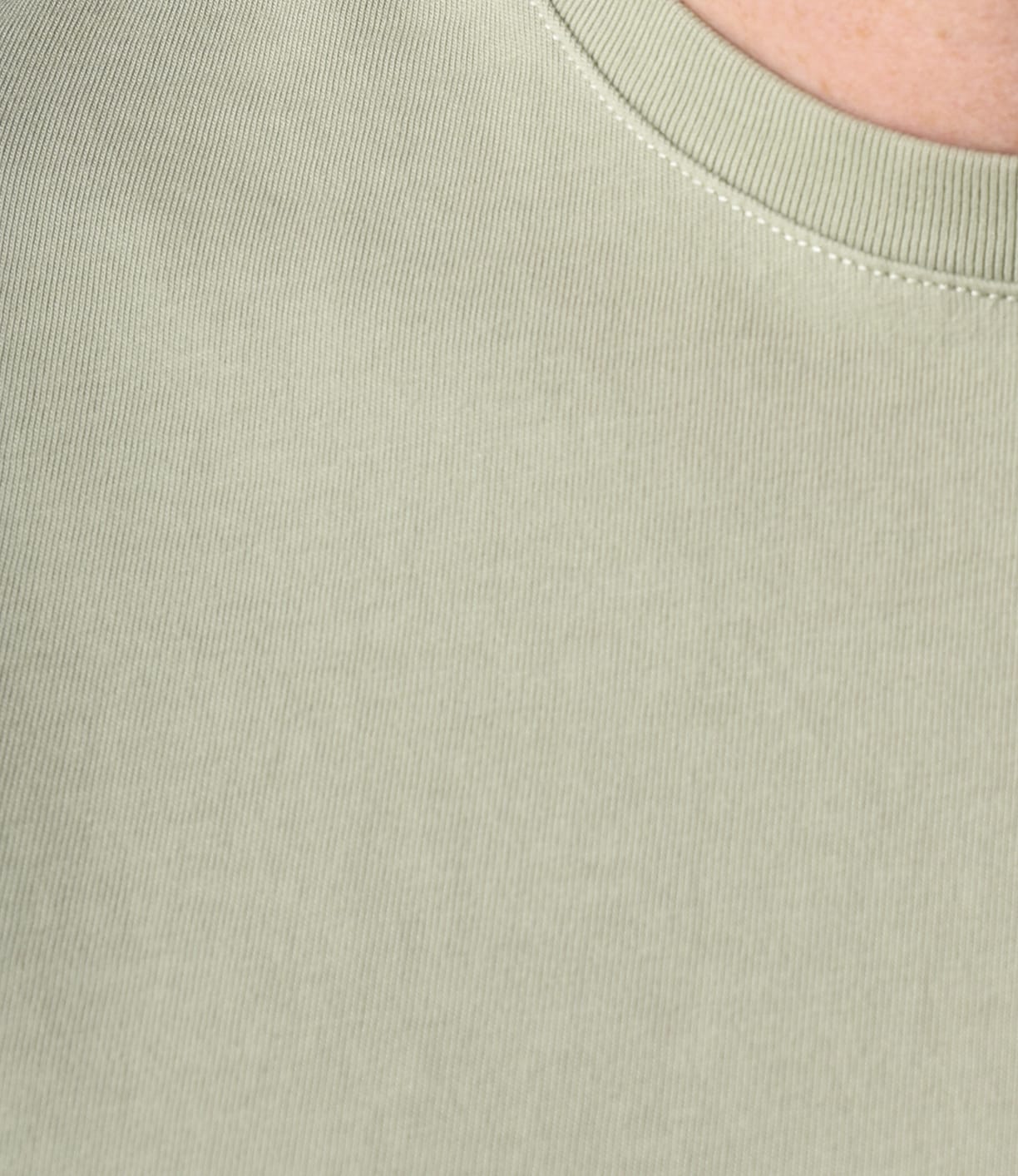 Close-up of the Best Made Co. Standard Pocket T-Shirt Haze in light sage green ribbed fabric, crafted from durable Peruvian tangüis cotton. Features collar seams and textured material—an everyday essential.
