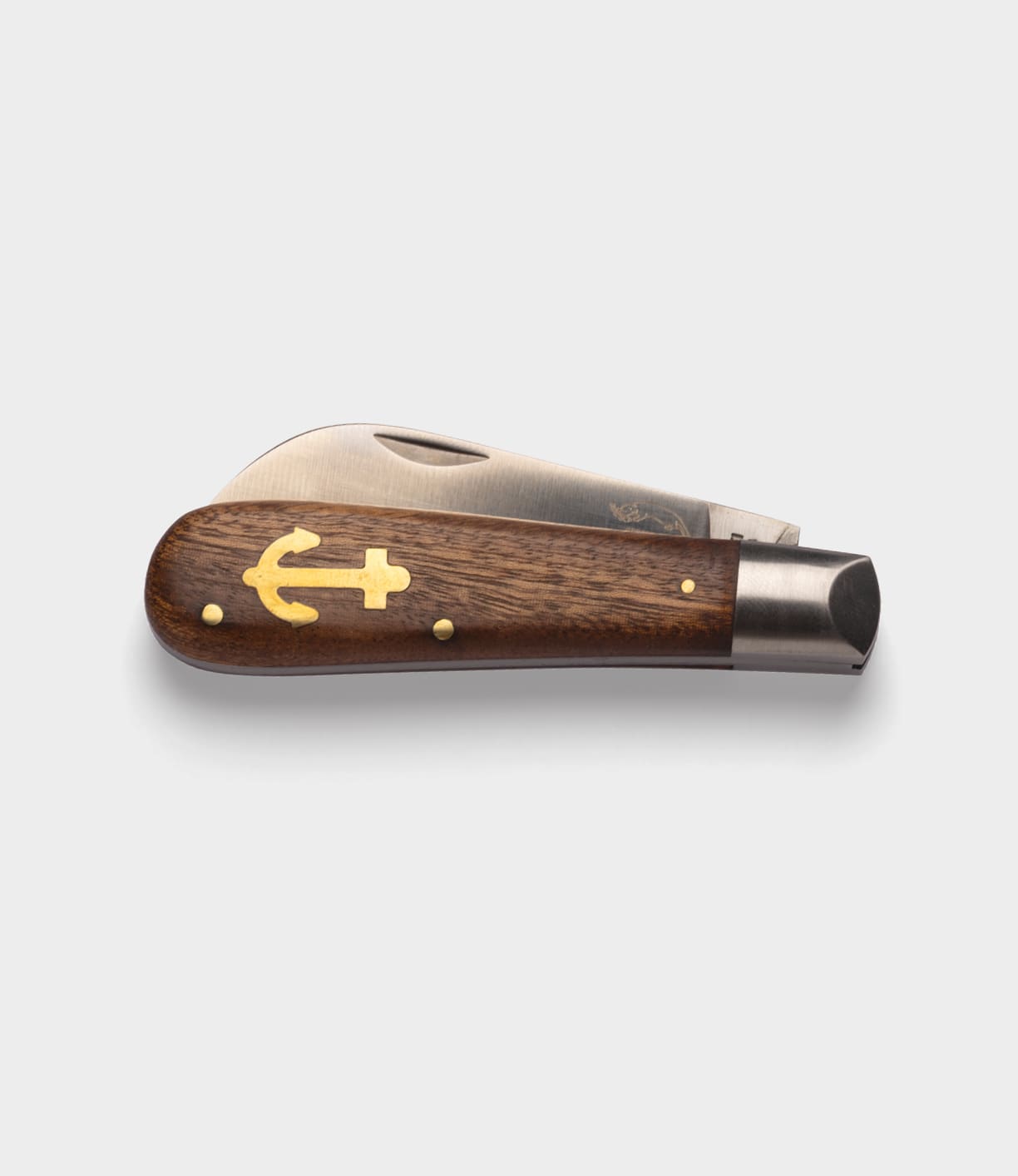 The Anchor Knife by Best Made Co. features a wooden handle with a gold anchor inlay and metal accents, shown partially open to display its sheepsfoot blade against a plain white background.