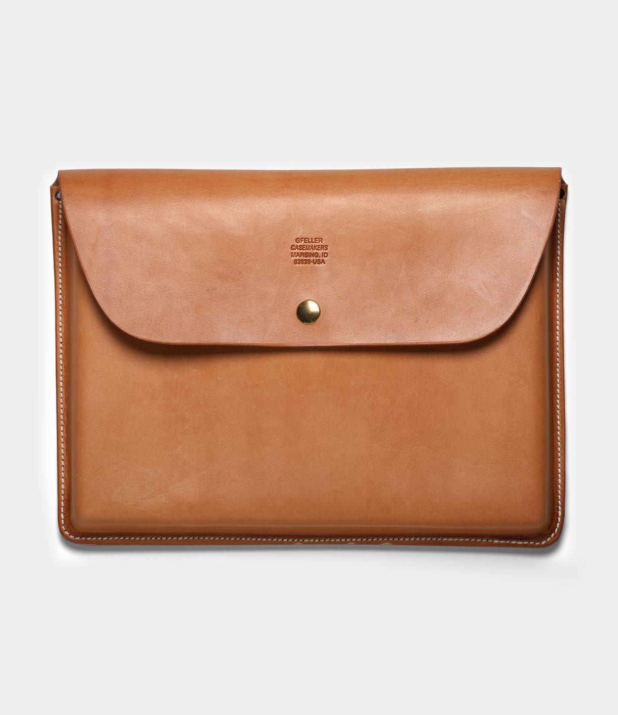 The Gfeller Case Large by Best Made Co. is a tan leather document case made from American russet skirting leather, with envelope styling, flap closure with brass snap, visible edge stitching, and a small embossed logo at the center top.
