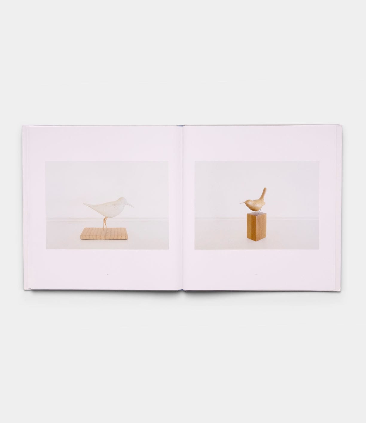 An open book titled "Boats, Books, Birds" by Best Made Co. displays two pages, each showing a photo of a wooden bird sculpture on a minimalist stand set against a plain background.