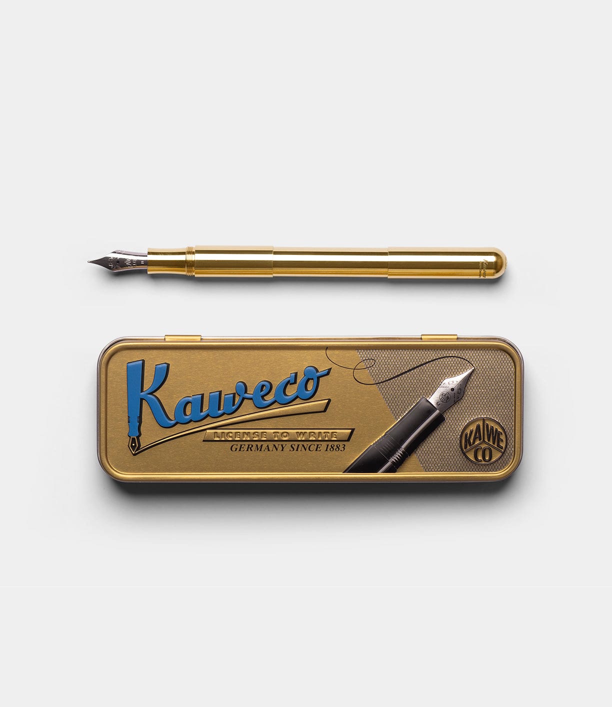 A Best Made Co. Kaweco Supra Fountain Pen is shown above a matching gold tin case with blue and black lettering and vintage-style graphics on the lid, set against a plain white background.