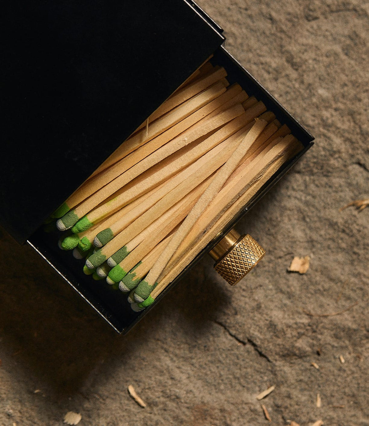 A black Best Made Co. Sliding Match Safe, partially open to reveal wooden strike-anywhere matches with green tips.