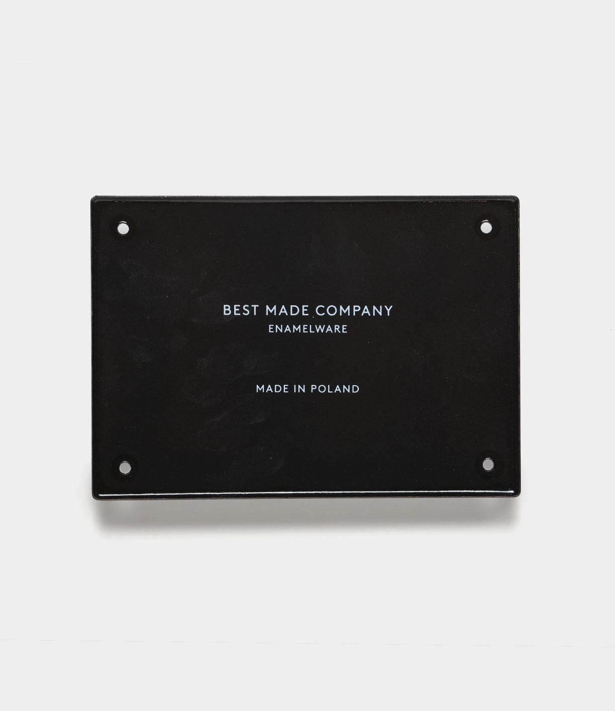 A black rectangular hand-crafted enamel steel sign by Best Made Co. with “Go Slow” text and four small holes—ideal as durable wall decor or for use as a classic enamel sign.