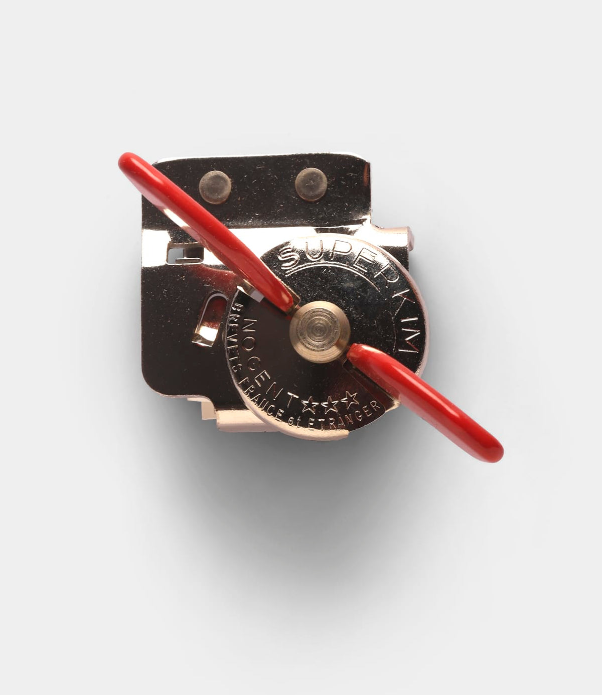 Nogent French Can Opener, a compact metal tool with a red handle and embossed lettering on the rotating dial, designed to be easy to use.