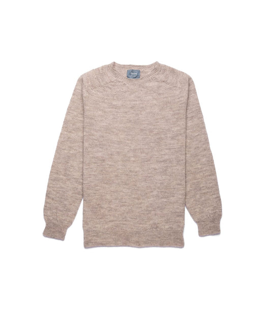 A man with short light brown hair and a mustache stands indoors, arms crossed, wearing the Best Made Co. 5-Gauge Shetland Sweater over a blue collared shirt and dark jeans, in front of wooden paneled walls.