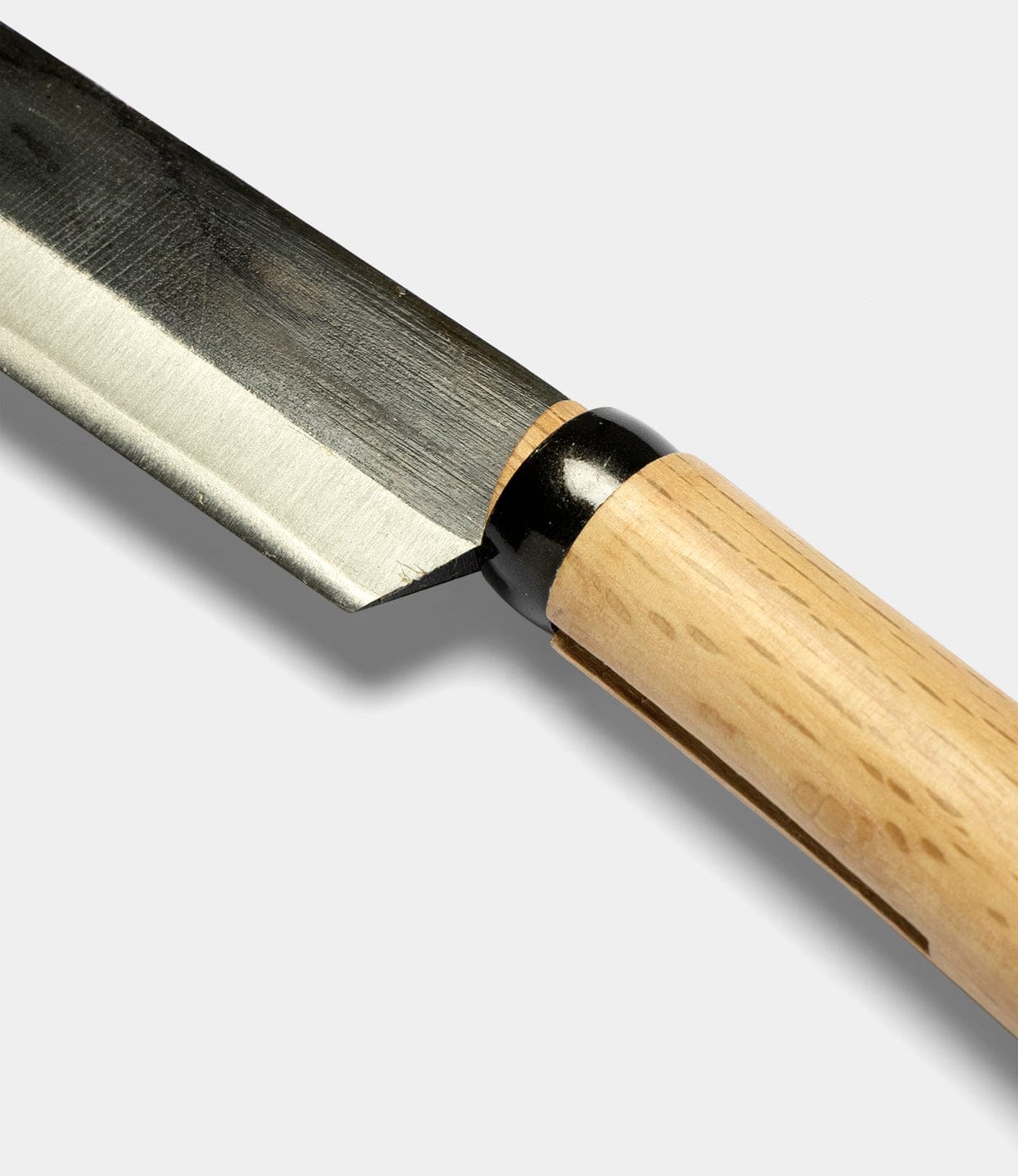 A close-up of the Best Made Co Japanese Hatchet, featuring a sharp stainless steel blade and a light wooden handle inspired by traditional Yasuki white steel craftsmanship, set against a plain white background.