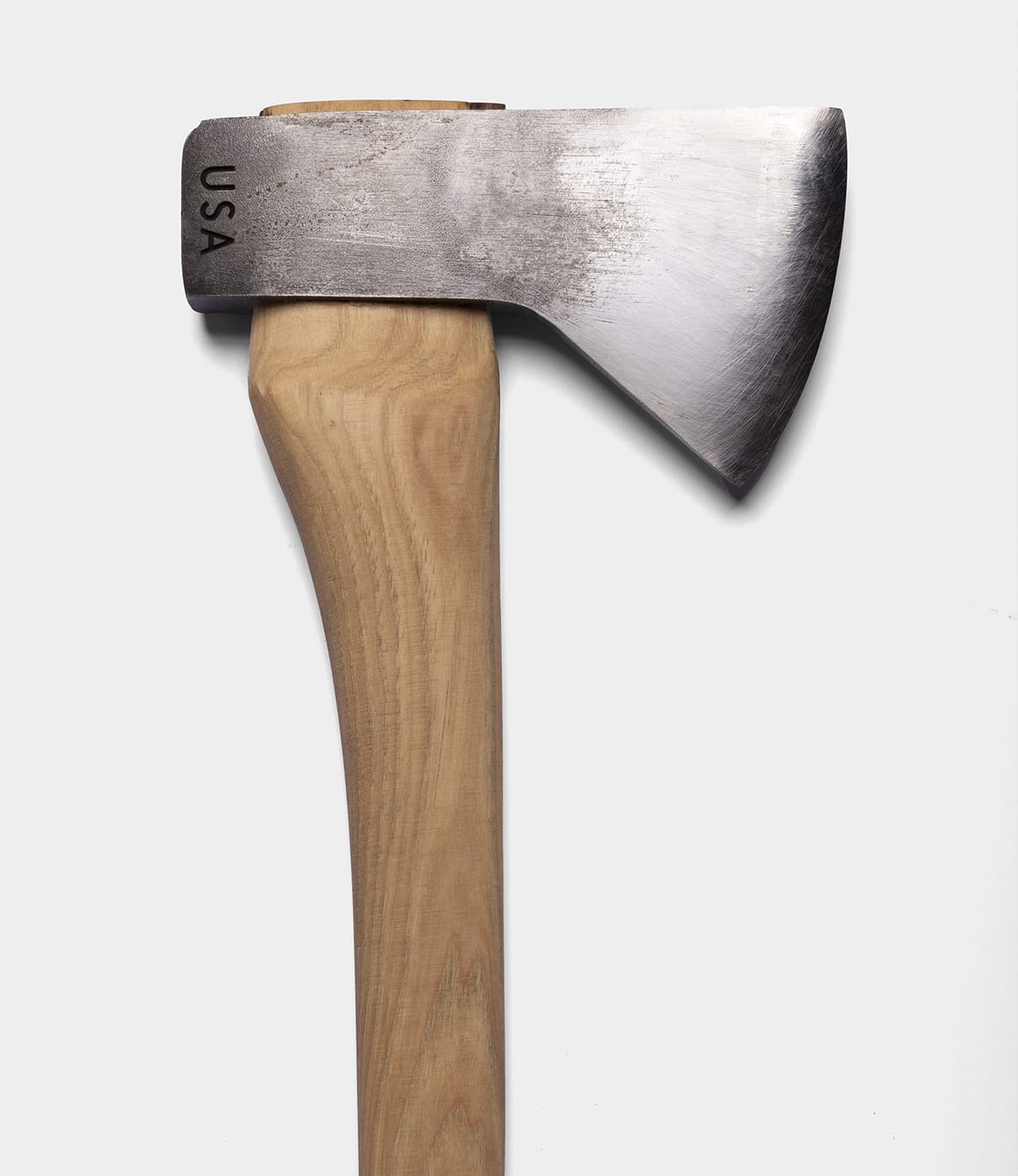 A close-up of The Optimist axe by Best Made Co. features a wooden handle and a 5160 carbon steel blade engraved with "USA," set against a plain white background.
