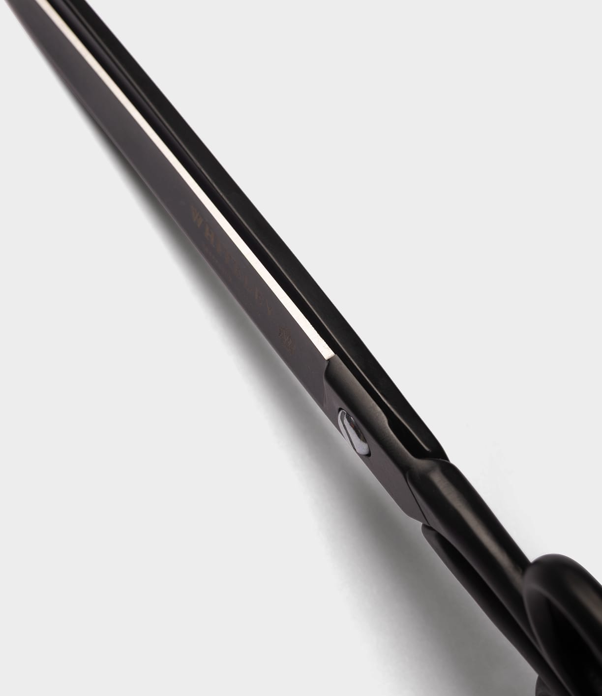 Close-up view of the black blade and handle of Best Made Co. Ten-Inch Paper Scissors, crafted from hot-forged carbon steel, photographed from an angle against a white background.