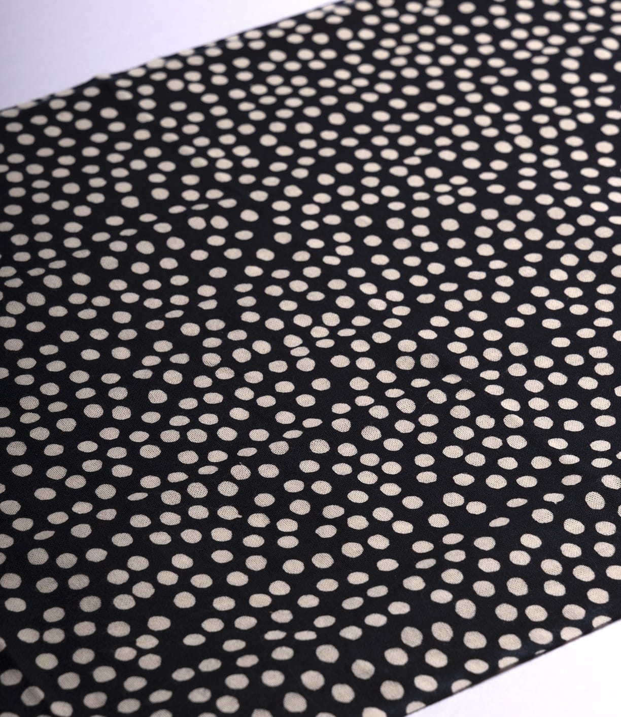The Arare Tenugui by Best Made Co. is a black fabric inspired by wabi-sabi, featuring off-white irregular dots for a dynamic, modern look that embraces imperfect beauty.