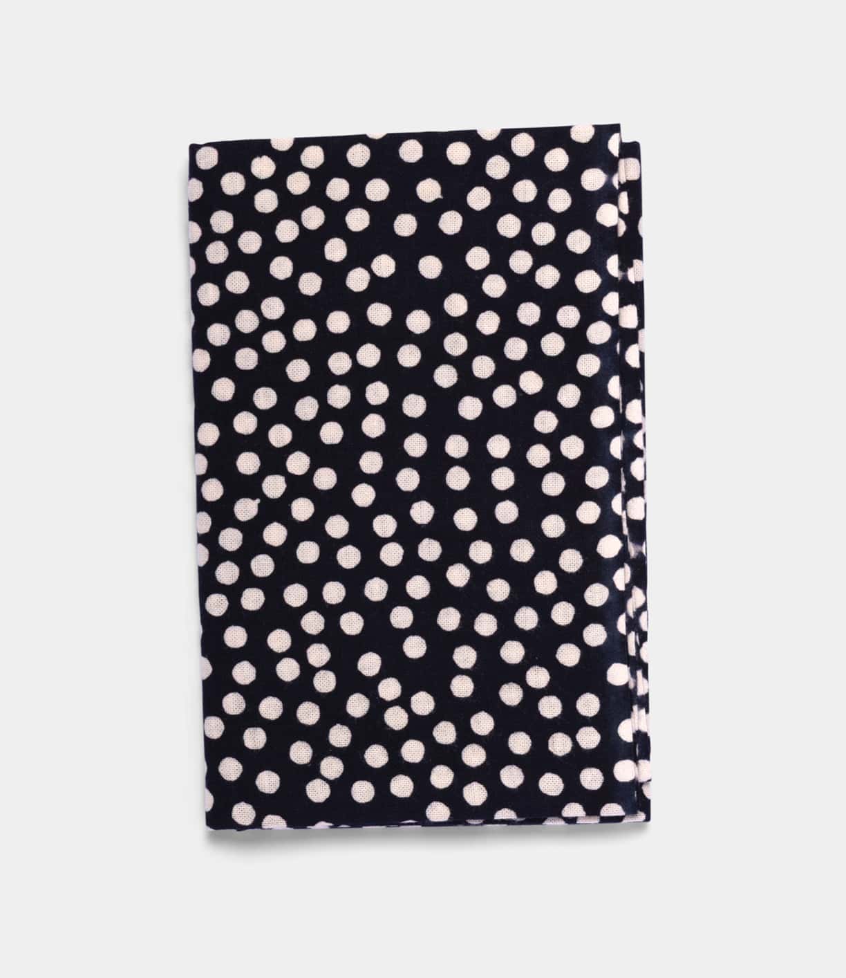 The Arare Tenugui by Best Made Co., a hand-dyed Japanese cloth with a black background and white polka dots crafted using the chusen technique, is shown folded on a plain light grey surface.