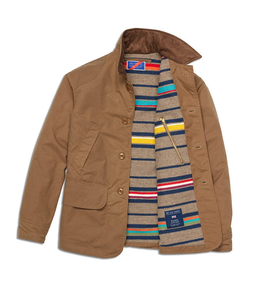 The Best Made Co. Wool-lined Waxed Field Jacket Tan features a wool lining, large front pockets, brown buttons, and an inner zippered chest pocket for stylish and functional all-weather wear.