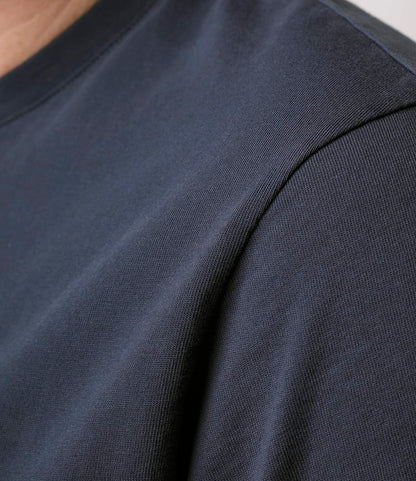 Close-up of a person wearing the Best Made Co. Standard Pocket T-Shirt in Navy, highlighting the shoulder and upper chest area with visible fabric texture and stitching. The background is plain and out of focus.