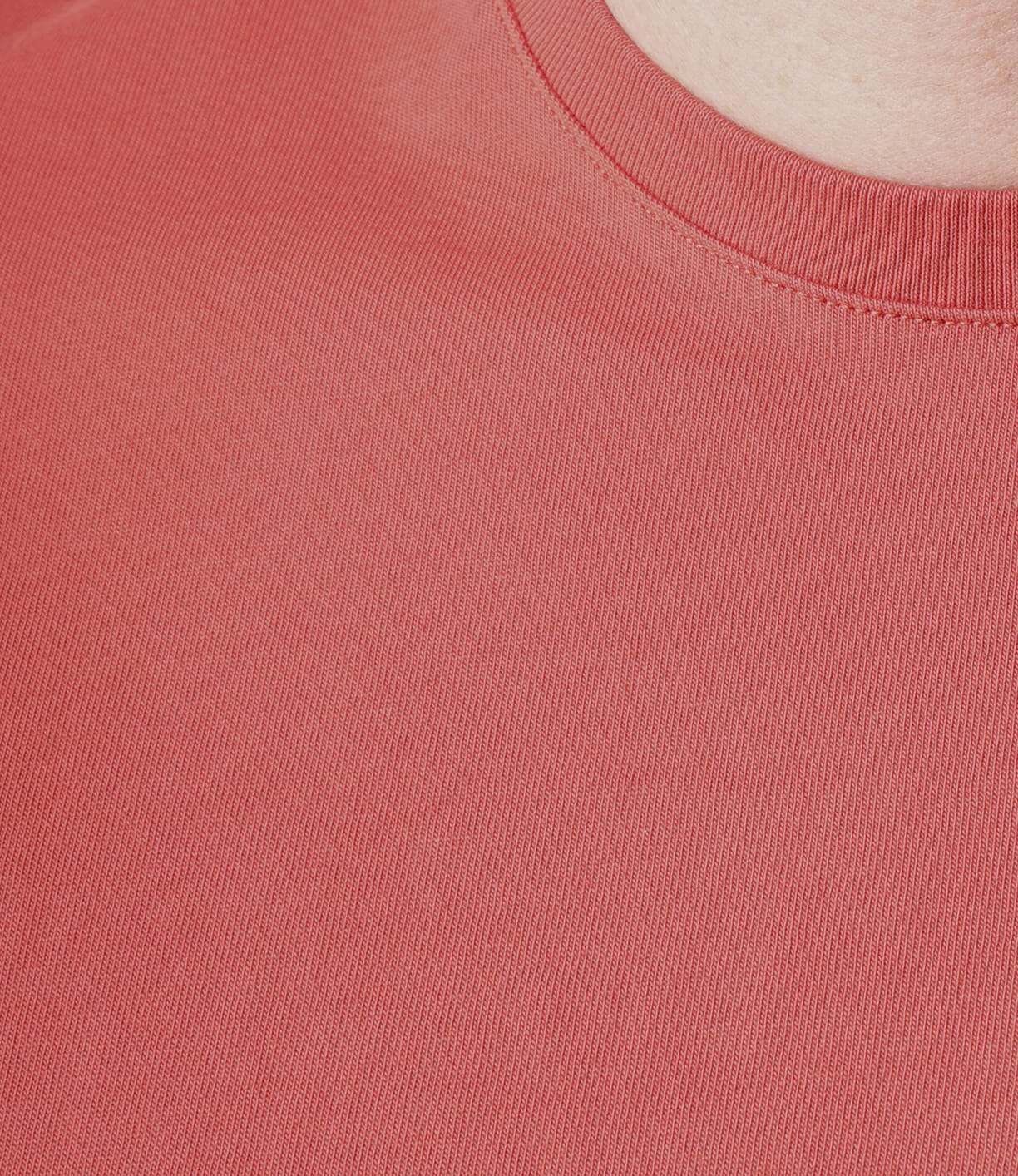 Close-up of a person wearing the Best Made Co. Standard T-Shirt Faded Red, crafted from soft Peruvian tangüis cotton, highlighting the textured fabric and collar with a glimpse of skin near the neckline.
