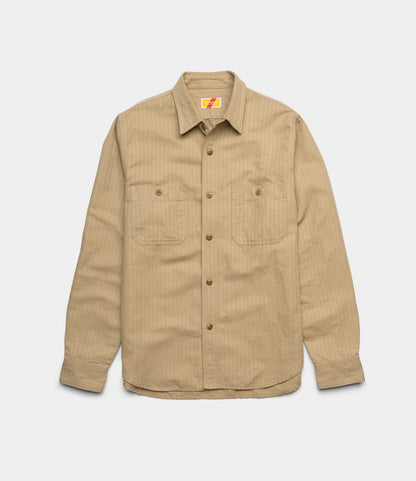 The Best Made Co. Cotton-Linen Workshirt Tan, with long sleeves, button-up front, chest pockets, and a collar, is laid flat on a white background—a refined workwear staple.