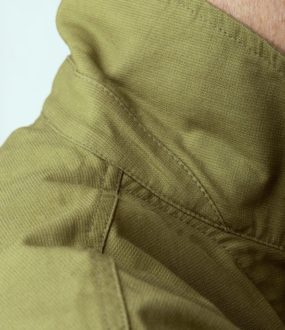 Close-up of khaki green Japanese cotton Panama cloth from the Best Made Co. Panama Cloth Service Jacket, highlighting visible stitching, seams, and detailed texture.