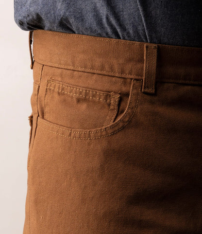 Close-up of a person wearing Best Made Co.'s Standard 5-Pocket Pant M2 in Field Brown, featuring visible front pocket, belt loop, seam, and classic straight-leg cut, paired with a dark blue shirt tucked into the waistband.
