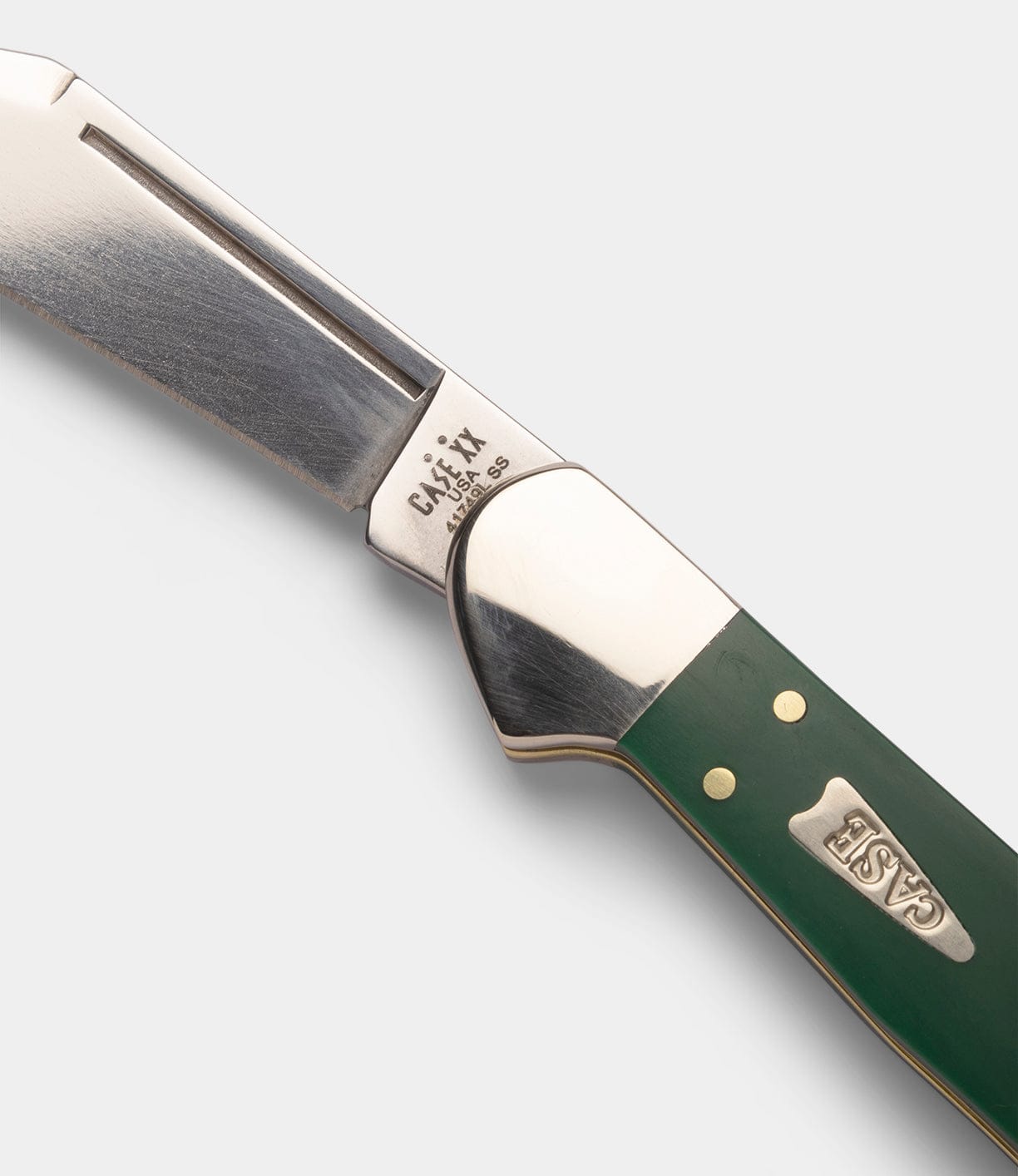 A close-up of a Best Made Co Mini Copperlock pocket knife with a partially open stainless steel blade and a green handle featuring a silver “BEST MADE CO” logo.