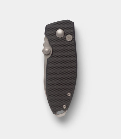 A black Best Made Co. CRKT Squid pocket knife is shown closed on a plain white background, highlighting its textured handle, visible button lock, and pivot.