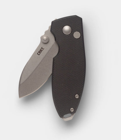 The Best Made Co. CRKT Squid features a partially open D2 steel blade, a textured black handle, thumb stud, button lock, and displays the CRKT logo on the blade.