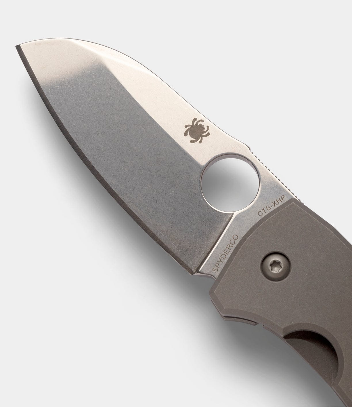 Close-up of the Spyderco Techno 2 folding knife by Best Made Co, featuring a CTS-XHP steel blade with thumb hole, spider logo, and Spyderco inscription, attached to a sturdy titanium framelock handle.