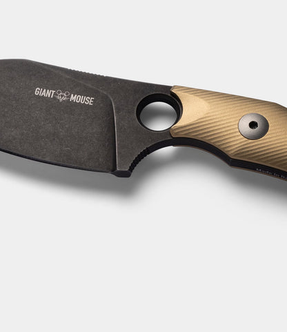 Close-up of the Best Made Co. GiantMouse GMF1-P (BMC Edition) knife featuring a black blade and textured, gold-colored brass scales handle, set against a plain white background.