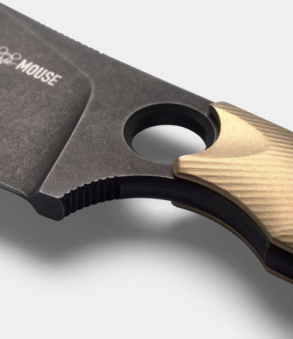 Close-up of the Best Made Co. GiantMouse GMF1-P (BMC Edition) knife, featuring a textured brass grip, large finger hole, and dark blade with partially visible "MOUSE" text against a plain light gray background.
