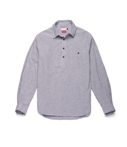 The Indigo Stripe Popover by Best Made Co. is a long-sleeve, button-up shirt with thin black and white vertical stripes, expertly crafted from premium Japanese cotton-linen. Featuring a classic collar and a front pocket on the left chest, this versatile year-round shirt is displayed laid flat against a plain white background.