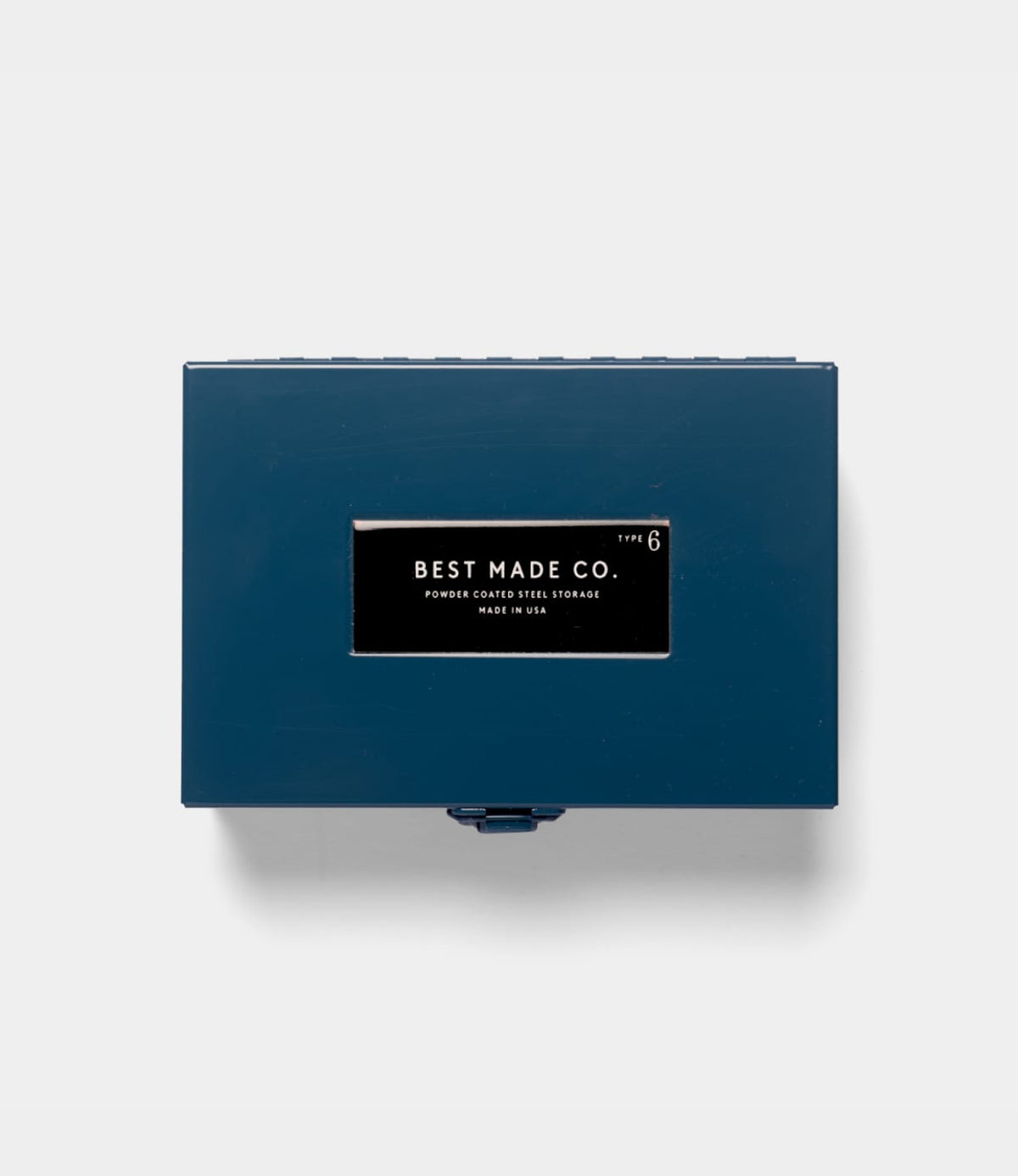 A rectangular blue Type 6 Strongbox by Best Made Co., crafted from durable steel and featuring a distinctive black and white “Best Made Co.” label on the lid, is photographed against a plain white background. Proudly made in the USA, this strongbox exemplifies reliable construction and quality craftsmanship.
