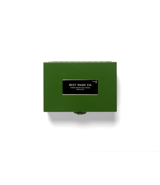 The Best Made Co. Type 6 Strongbox Green is a durable powder-coated steel storage box, featuring a black and white label that reads “Best Made Co. Type 6 Powder Coated Steel Storage Made in USA.” Placed on a plain light gray background, this strongbox from the Best Made collection offers secure storage for your valuables.