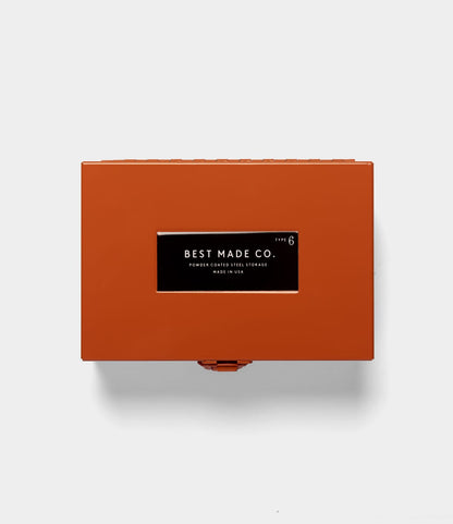 A rectangular, orange Type 6 Strongbox by Best Made Co. sits centered on a plain, light gray background, exemplifying secure storage and the reliability of a durable steel box.