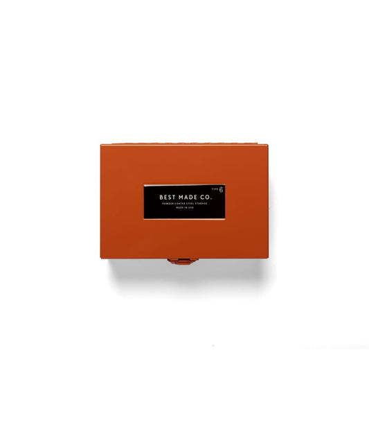 A rectangular, orange Type 6 Strongbox by Best Made Co. sits centered on a plain, light gray background, exemplifying secure storage and the reliability of a durable steel box.