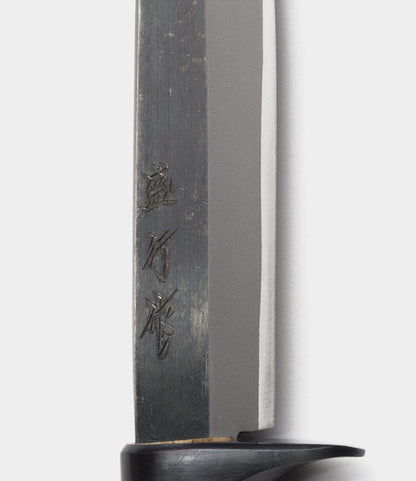 Close-up of the Hotta San Hunting Knife by Best Made Co., featuring Japanese characters engraved on Yasuki blue steel near the handle. The blade has a straight edge, a black guard at the base, and is set against a plain light background.