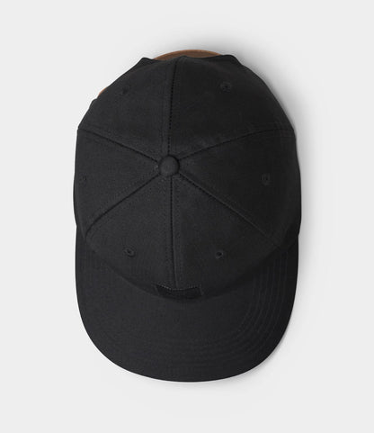 The Best Made Co. Military Cord Ball Cap Black is shown from above, displaying its top panels, crown button, and curved brim. This plain black corduroy cap has no visible logos or designs and is set against a light gray background.