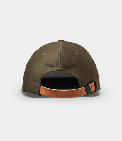 The Military Cord Ball Cap Olive Drab by Best Made Co. is shown from the back with a brown leather adjustment strap embossed with "BEST MADE CO. NEW YORK," set against a plain light gray background.