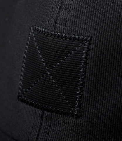 Close-up of black fabric with a square patch and X-pattern stitching, showcasing the texture and details of the Best Made Co. Military Cord Ball Cap Black.