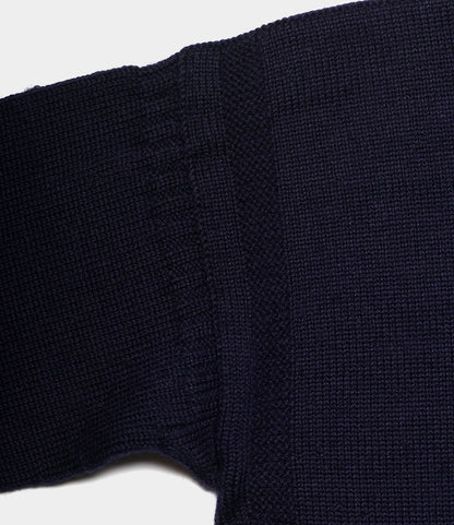 Close-up of a navy blue Guernsey Sweater by Best Made Co., highlighting textured stitching and ribbed cuffs, with traditional seamless knitting shown against a white background.