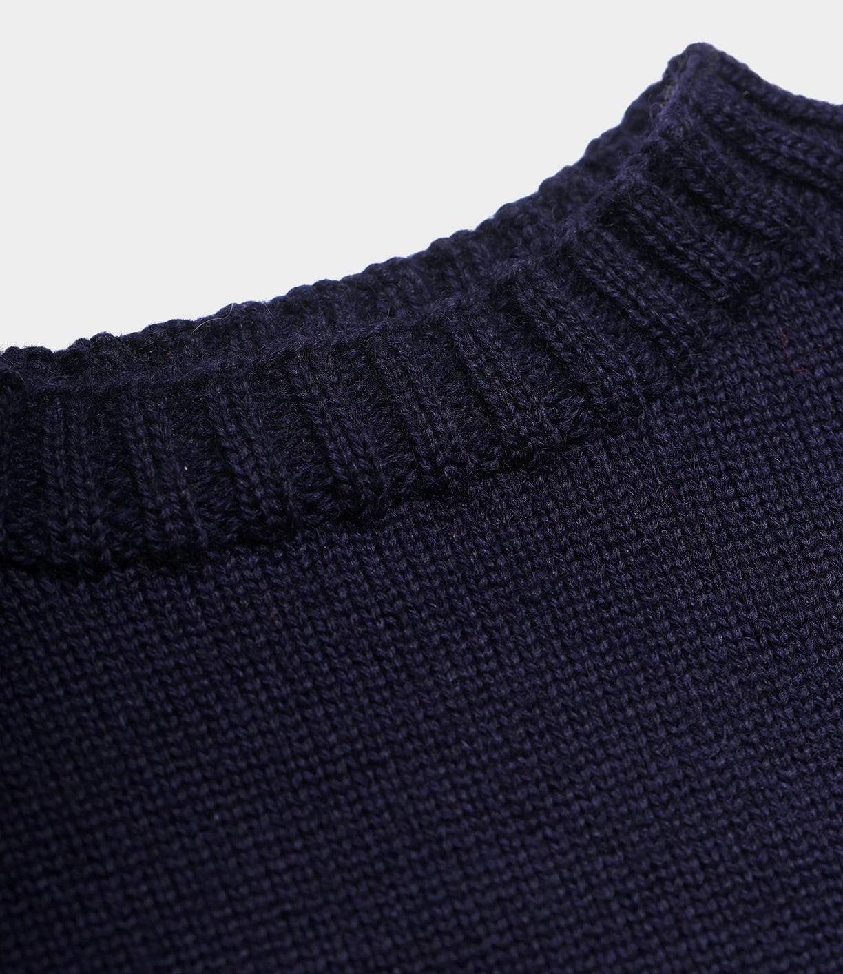 Close-up of the Best Made Co. Guernsey Sweater in dark navy, highlighting its ribbed collar and textured knit fabric crafted with traditional seamless knitting.