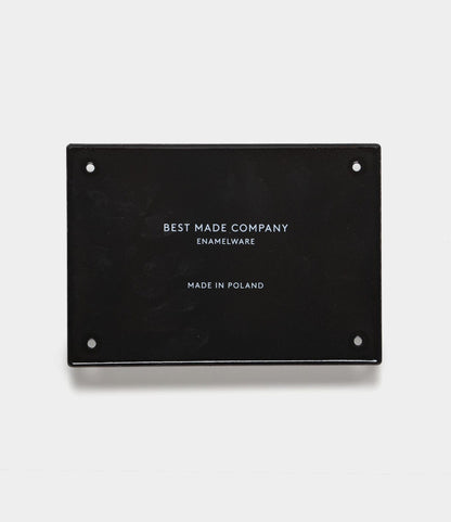 A black rectangular hand-crafted enamel steel sign by Best Made Co. with “Go Slow” text and four small holes—ideal as durable wall decor or for use as a classic enamel sign.