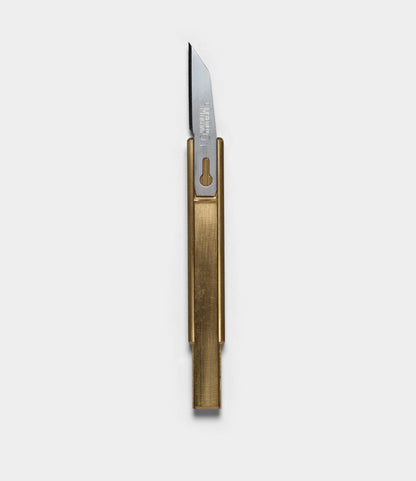 The Best Made Co. Studio Knife features a rectangular brass handle and exposed steel blade, shown on a plain light gray background—perfect for precision tasks in any workshop.