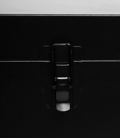Close-up of a secure black metal latch on the matte 22-gauge steel surface of the Best Made Co. Rolling Footlocker, with the centered latch fastened shut—offering durable storage for your valuables.