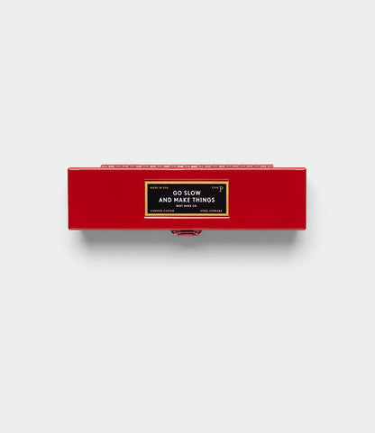 A rectangular red Best Made Co. Type P Strongbox, Go Slow Edition, with a black and gold "GO SLOW AND MAKE THINGS" label on top, is set against a plain light gray background.