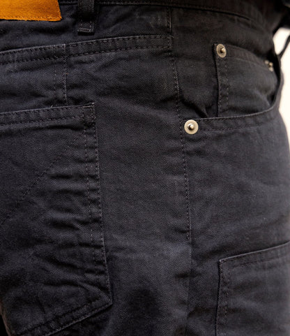 Close-up of Best Made Co. Field Pant Special Edition Navy, made from durable cotton twill. Features include a visible metal rivet on the side pocket, a tan leather patch at the waistband, reinforced stitching, and textured fabric.