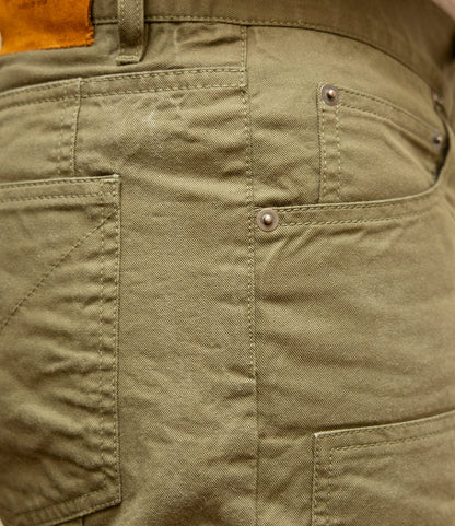 Close-up of the side and back pocket of the Best Made Co. Field Pant Special Edition Olive Drab, highlighting detailed stitching, rivets, a belt loop, and a brown leather patch on the cotton twill waistband.