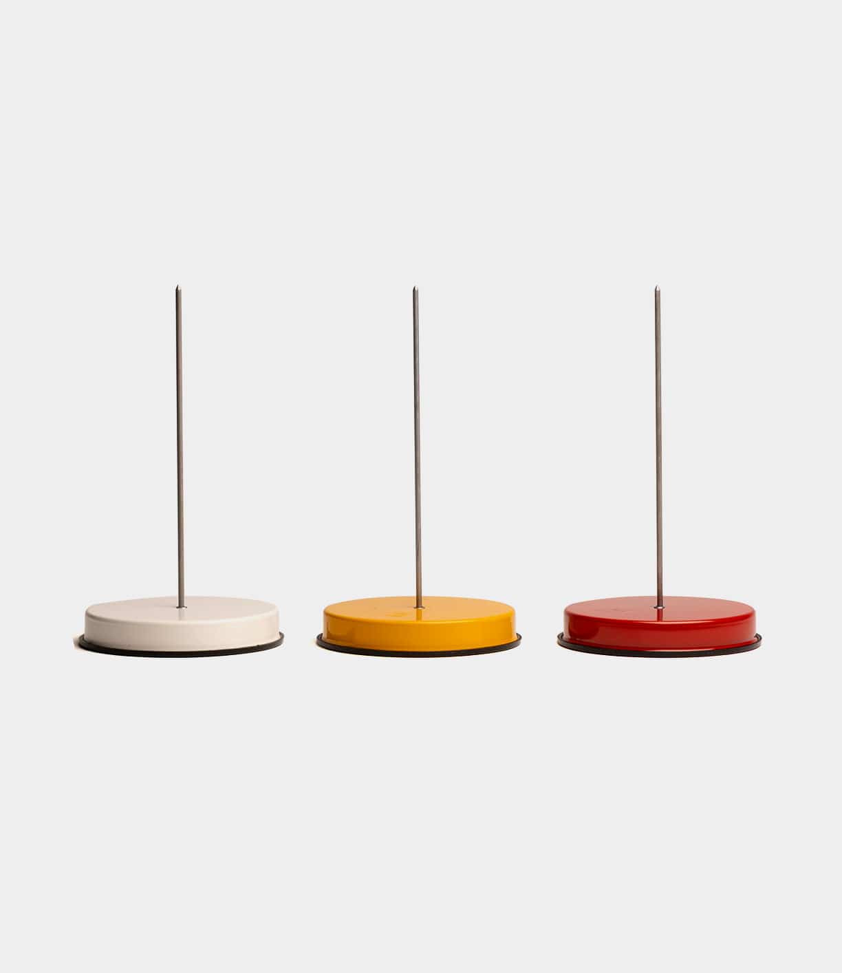 Three Best Made Co. Italian Receipt Spikes are displayed in a row on a plain background, featuring round bases in white, yellow, and red—combining stylish design with practical function as memo holders or paper organizers.