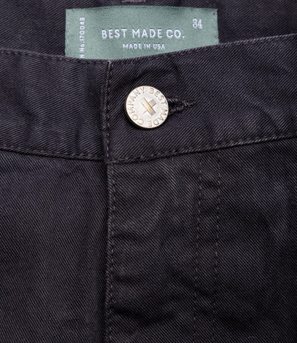 Close-up of the Field Pant Special Edition Navy waistband, featuring a metallic button engraved with Best Made Co. NYC and a green label reading Best Made Co. 34 Made in USA. Durable cotton twill fabric and detailed stitching are clearly visible.