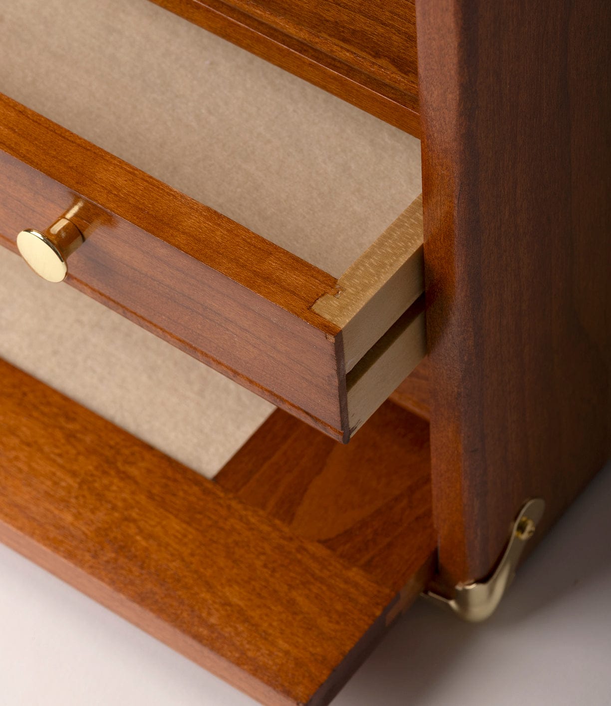 Close-up of the Best Made Co. Gerstner 41D Founder’s Edition, a wooden machinist chest with a polished American cherry finish, gold metal hardware accents, partially opened drawer with a gold knob and beige interior.