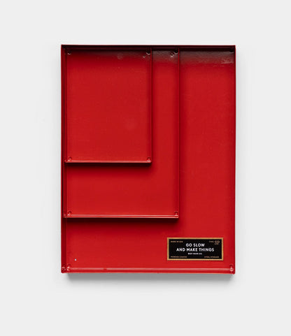 The Best Made Co. Spare Parts Trays (Set of 3), Go Slow Edition, are red rectangular metal organizers with different-sized compartments and a black and gold "GO SLOW AND MAKE THINGS" label, perfect for organizing tools or spare parts. Plain white background.