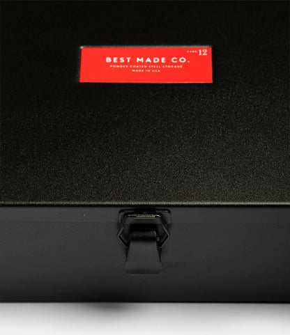 A close-up of the Best Made Co. Type 12 Strongbox in matte black, featuring a durable steel build, central latch, and red label—perfect for safe storage.