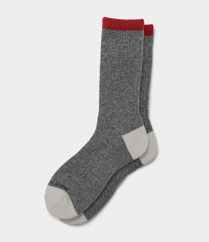 Best Made Co.’s Japanese Wool Socks feature gray merino wool with white toes and heels, plus a red band at the top, shown laid flat on a white background—perfect for cold weather.