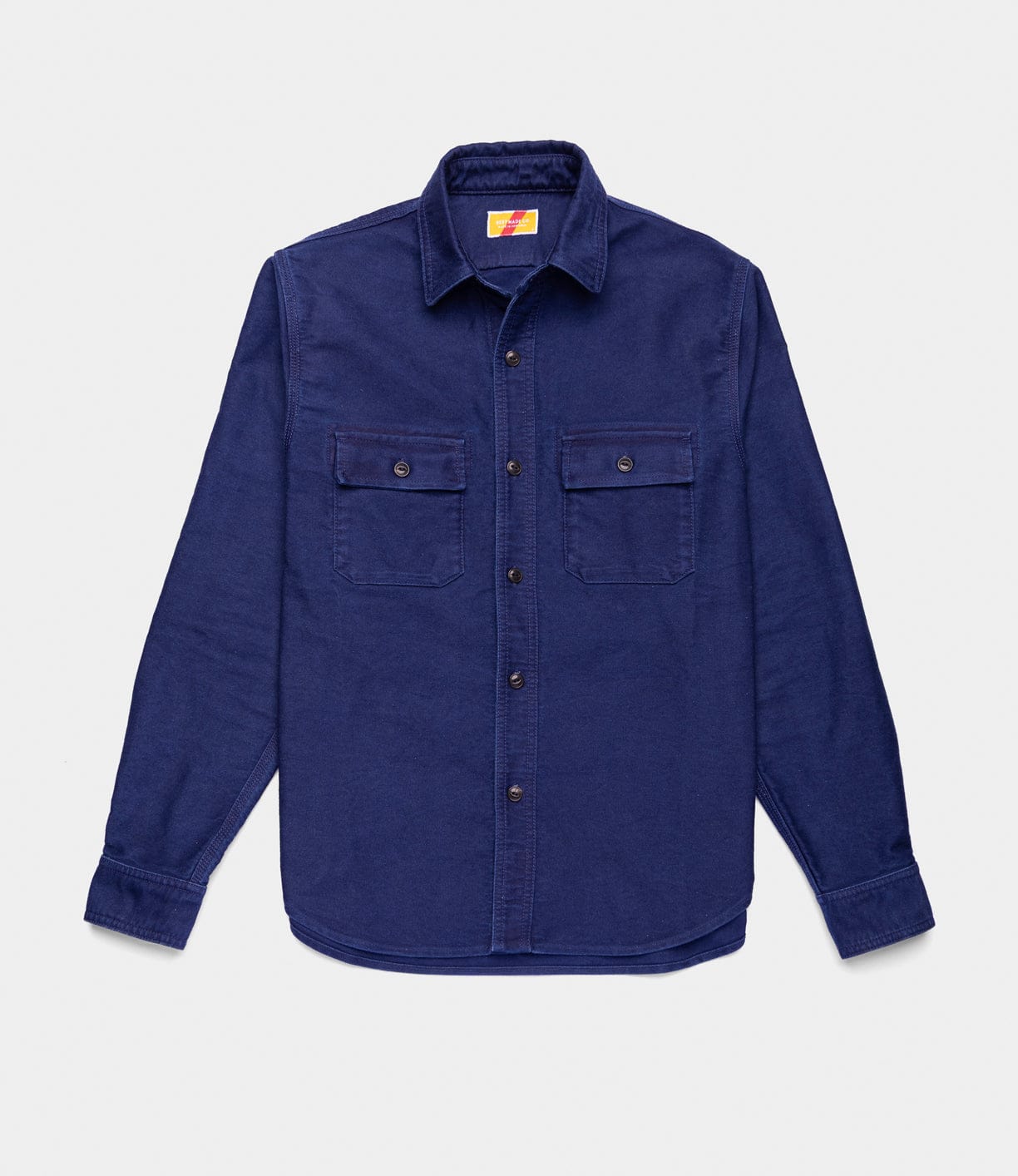 The Best Made Co Indigo Moleskin Work Shirt is a dark blue, long-sleeve, button-up shirt with two button-flap chest pockets, shown laid flat on a white background.